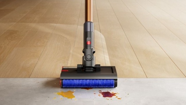Dyson PencilWash wet floor cleaner cleaning a mess on the floor. 