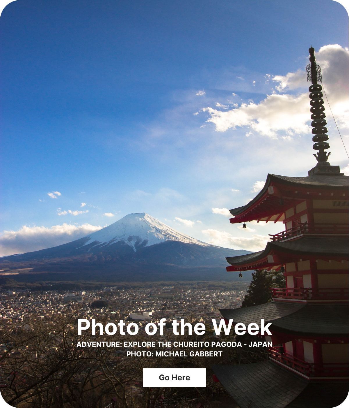 A pagoda with sloping roofs rises to the right and a snowcapped mountain is far off to the left.