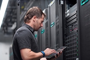 a male system administrator in datcenter interacting with storage systems