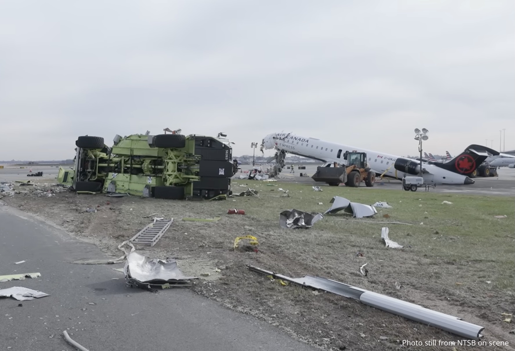 Still taken from NTSB b-roll video showing the final position of the aircraft and truck on the airfield.